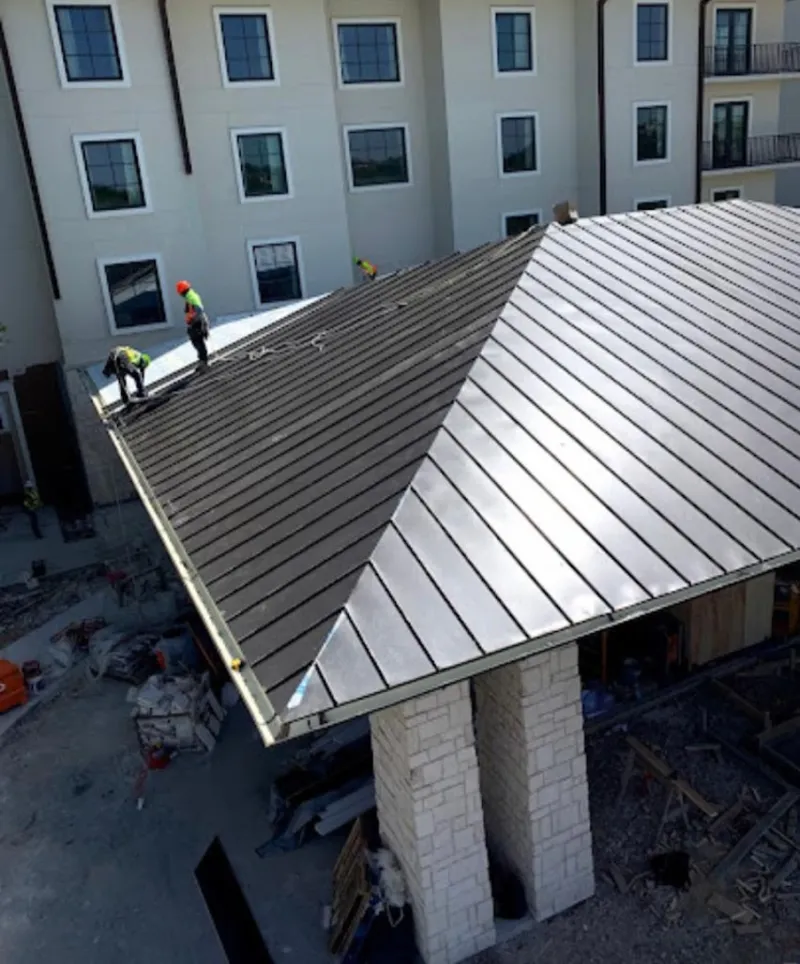 Crew installing standing seam metal roof panels on a commercial project in Mount Pleasant